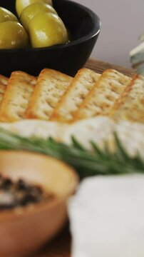 Bowl of green olives, spices, crispy biscuits, jam, rosemary herb, cheese and walnuts