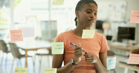 Black woman, thinking and writing in schedule planning, creative strategy or ideas on glass board...