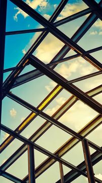 Construction of a modern building framework under a bright blue sky with scattered clouds
