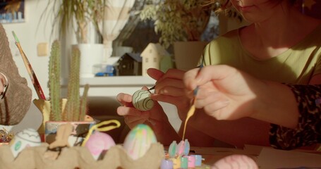 Easter eggs painting. Family gathers around the table, preparing for Easter by decorating eggs and creating festive decorations. Fosters bonding and shared memories. Easter crafts preparing to holiday