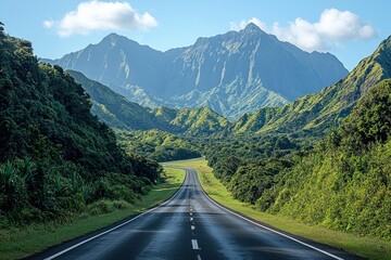 Naklejka premium Empty highway through lush valley towards majestic mountains, ideal for travel ads