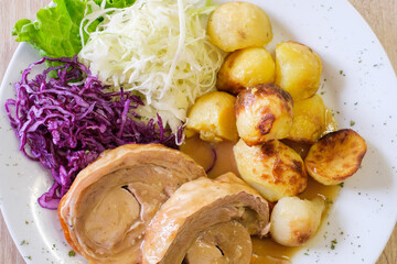 Roasted meat with roasted potatoes cabbage and red cabbage