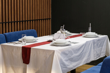 A formally set table awaits diners in a modern setting