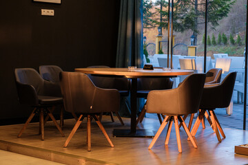 Modern dining area with a round table and comfortable chairs overlooking a scenic view