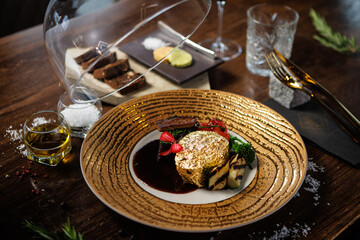 Exquisite gold-plated beef steak with grilled vegetables, cherry tomatoes, and a savory sauce....