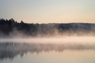 Sunrise with fog forming over a lake in Sweden, at dawn. Romantic silence