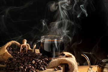 black coffee in coffee cup There are roasted coffee beans on the table. with a black background and dark colors