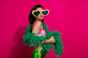 Stylish Woman Posing With Green Feather Boa and Heart Sunglasses Against Magenta Background