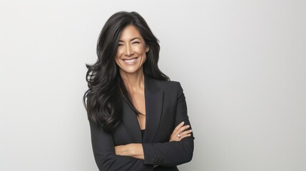 Attractive smiling businesswoman with her arms crossed photographed against a white background