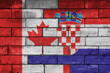 colourful painted big flag of canada and flag of croatia on a massive old brick wall background....