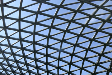 A modern architectural design featuring a triangular glass roof, maximizing natural light penetration into the building while adding an aesthetic and eco friendly element to the structure.