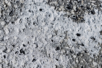 abstract close-up of salt mineral on sealed concrete floor in winter weather surface texture residue from tires background