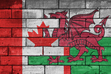 colourful painted big flag of canada and flag of wales on a massive old brick wall background. concept