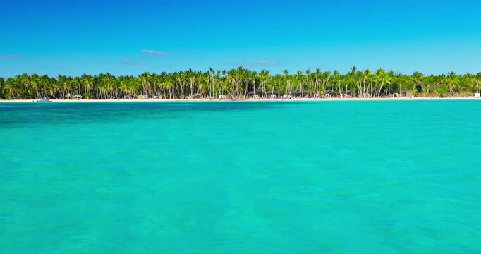 Summer vacation of Caribbean islands. Boat travel in Caribbean sea seashore view of tropical island beach with exotic palm trees, Dominican Republic