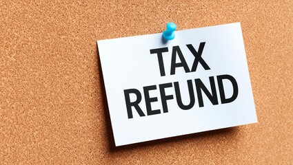 A note pinned to a corkboard displays the words "TAX REFUND," highlighting a financial topic relevant to personal finance and tax returns.