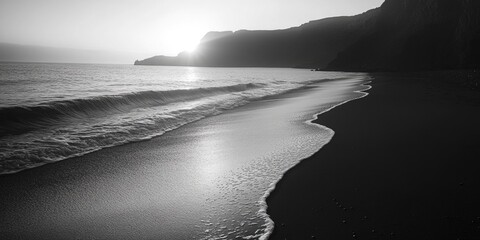 Beautiful seaside view with a gentle sunset over a sandy beach and rocky shore.