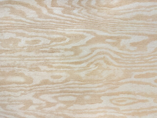 Abstract random ripple wave pattern carved on yellow wood panel. Wooden veins shape pattern in beige color. Seamless background texture.