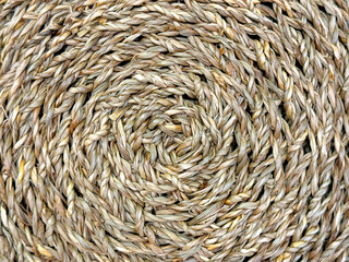 Close up of circular or round rattan wicker basket in natural brown rattan color. Seamless background texture