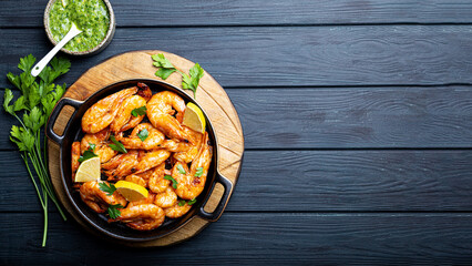  Fried shrimps with lemon and green on a round board, top view, copy space for text