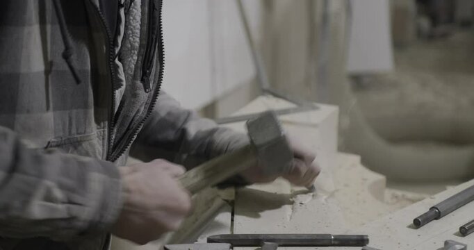 stonemason chiseling and working on part of gothic cathedral