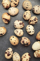 Quail eggs in plate on dark background. Vertical photo