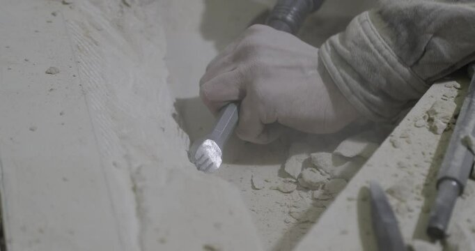 stonemason chiseling and working on part of gothic cathedral
