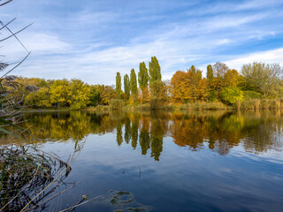 piękne jesienne kolory drzew odbijające się w gładkiej tafli wody
