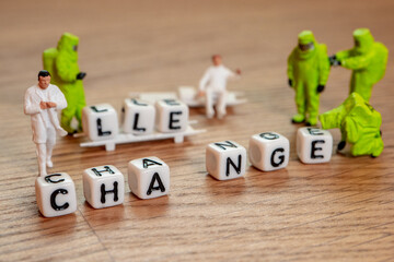 challenge creating new word change on wooden background with miniature figurines in hazmat and...