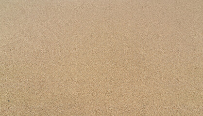 Stones and sand in the summer day. Yellow sand on the beach near a sea.