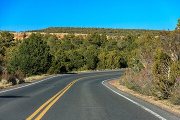 A road with a curve and a hill in the background