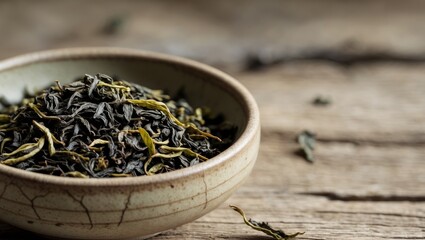 Fototapeta premium Tea leaves in a bowl with natural textures and space for custom text ideal for tea related content and product promotion.