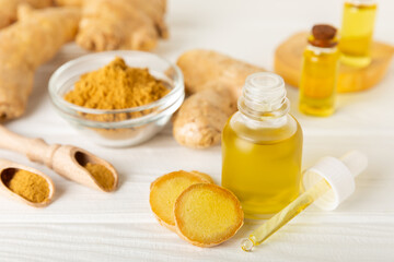 Ginger essential oil on texture background. Fresh ginger slices. Essence, serum, oil. Alternative medicine. Phytotherapy. Health and beauty concept. Place for text. Copy space.