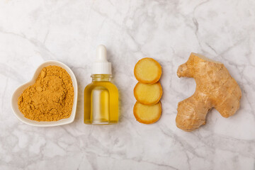 Ginger essential oil on texture background. Fresh ginger slices. Essence, serum, oil. Alternative medicine. Phytotherapy. Health and beauty concept. Place for text. Copy space.
