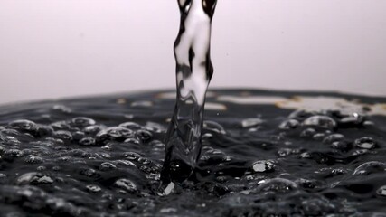 Liquids interacting.  Water pouring into water. Surface action. 80x slomo