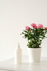 white blank plastic bottle for garden and domestic plant fertilizer on white table.
