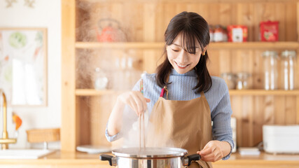 キッチンで料理をする笑顔の女性