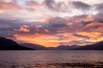 Sonnenaufgang über dem Meer mit Bergen im Hintergrund
