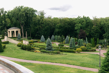 Well-maintained landscaping design featuring a gazebo, manicured lawns, a variety of trees, and winding pathways creating an inviting and luxurious outdoor space
