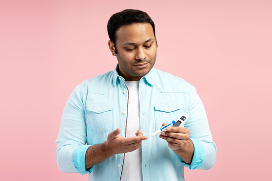 Man using glucose meter checking blood sugar level at home
