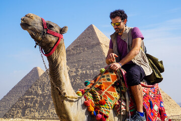 Nomadic Travel Experience in Giza Egypt with a Man Riding a Camel in Front of the Legendary...