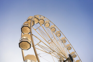 White Ferris Wheel Spinning Against a Clear Blue Sky on a Bright Sunny Day	
