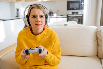 Woman Focused Playing Video Game with Headphones in a Cozy Living Room