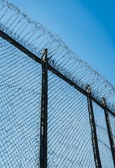 High security fence with barbed wire on border