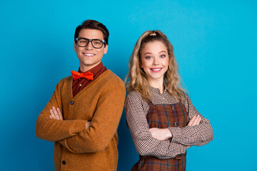 Young couple in retro style posing cheerfully with blue background.