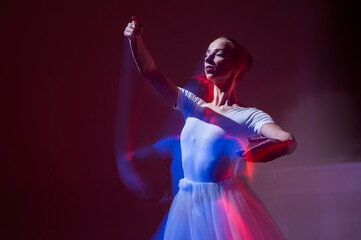 Caucasian woman dancing classical dance in tutu . Long exposure photo. 