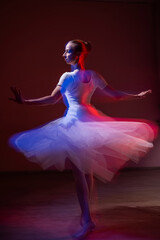 Fototapeta premium Caucasian woman dancing classical dance in tutu . Long exposure photo. 