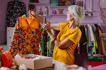 Senior woman selling clothes and accessories online. Managing a Small business during the seniority...