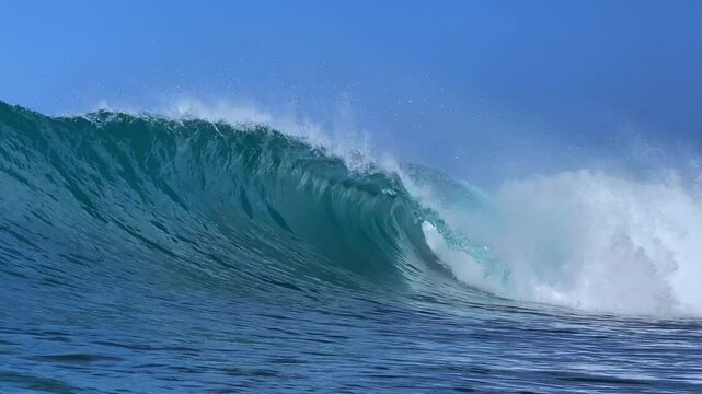 Perfect blue ocean wave breaks on the shore in Indonesia.Slow motion video.View from the water