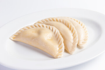 Large dumplings in a plate. On a light background.