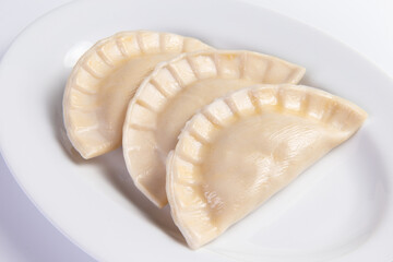 Large dumplings in a plate. On a light background.